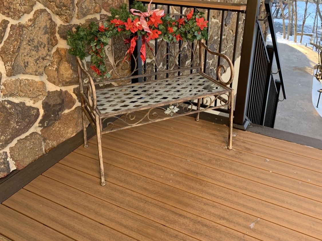Composite deck in Deckorators Sedona with single board frame in Deckorators Ironwood and black metal deck railing in Colorado Springs