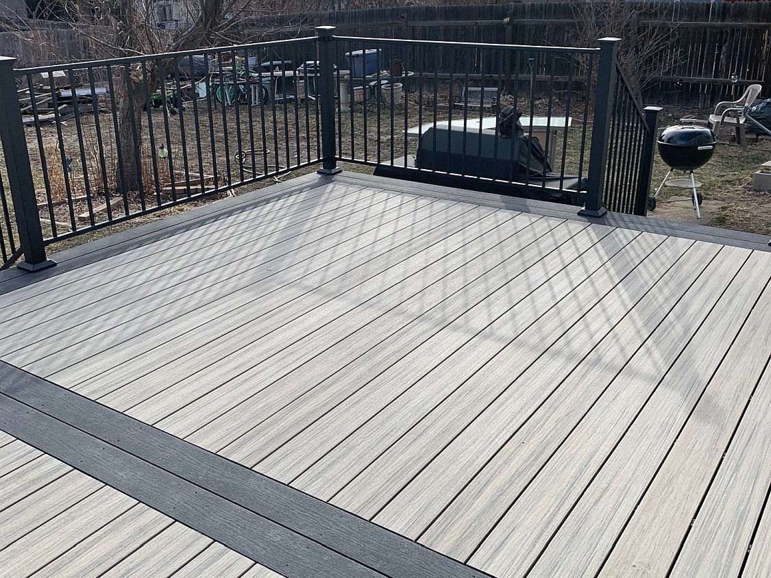 Composite deck with double picture frame border and divider boards and a metal deck railing in Colorado Springs