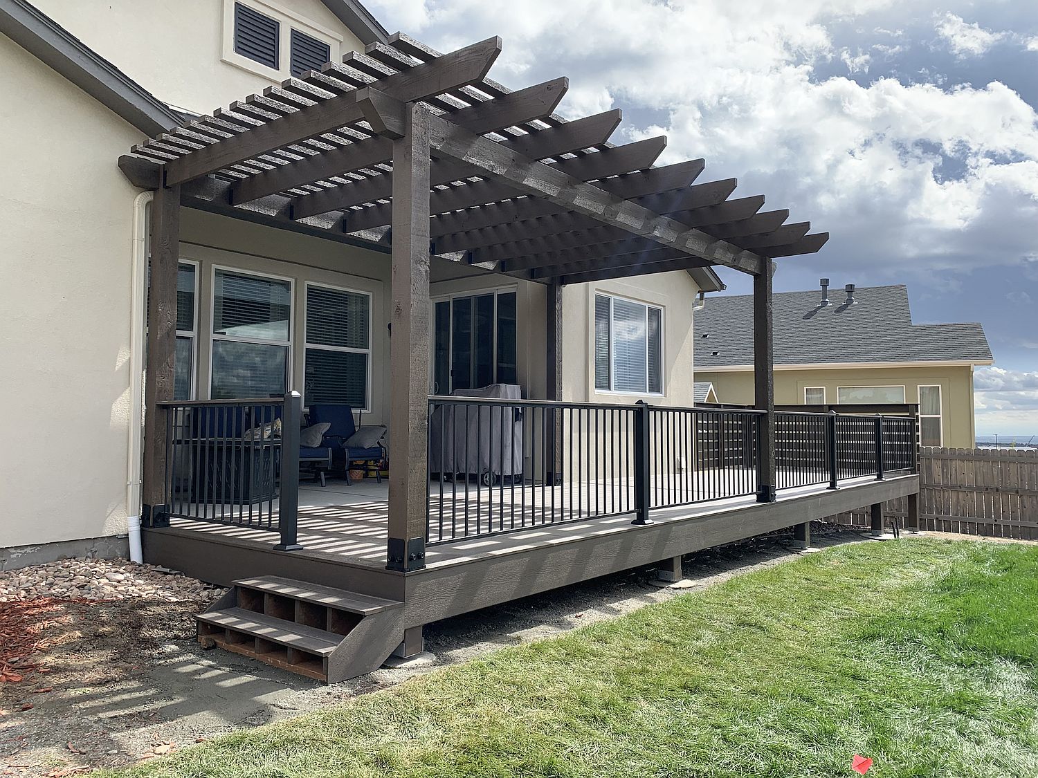 Composite deck in Colorado Springs with metal deck railing cedar pergola and two privacy screens