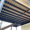 Underside view of an elevated composite deck in Colorado Springs with Fortress Evolutions powder-coated steel deck framing