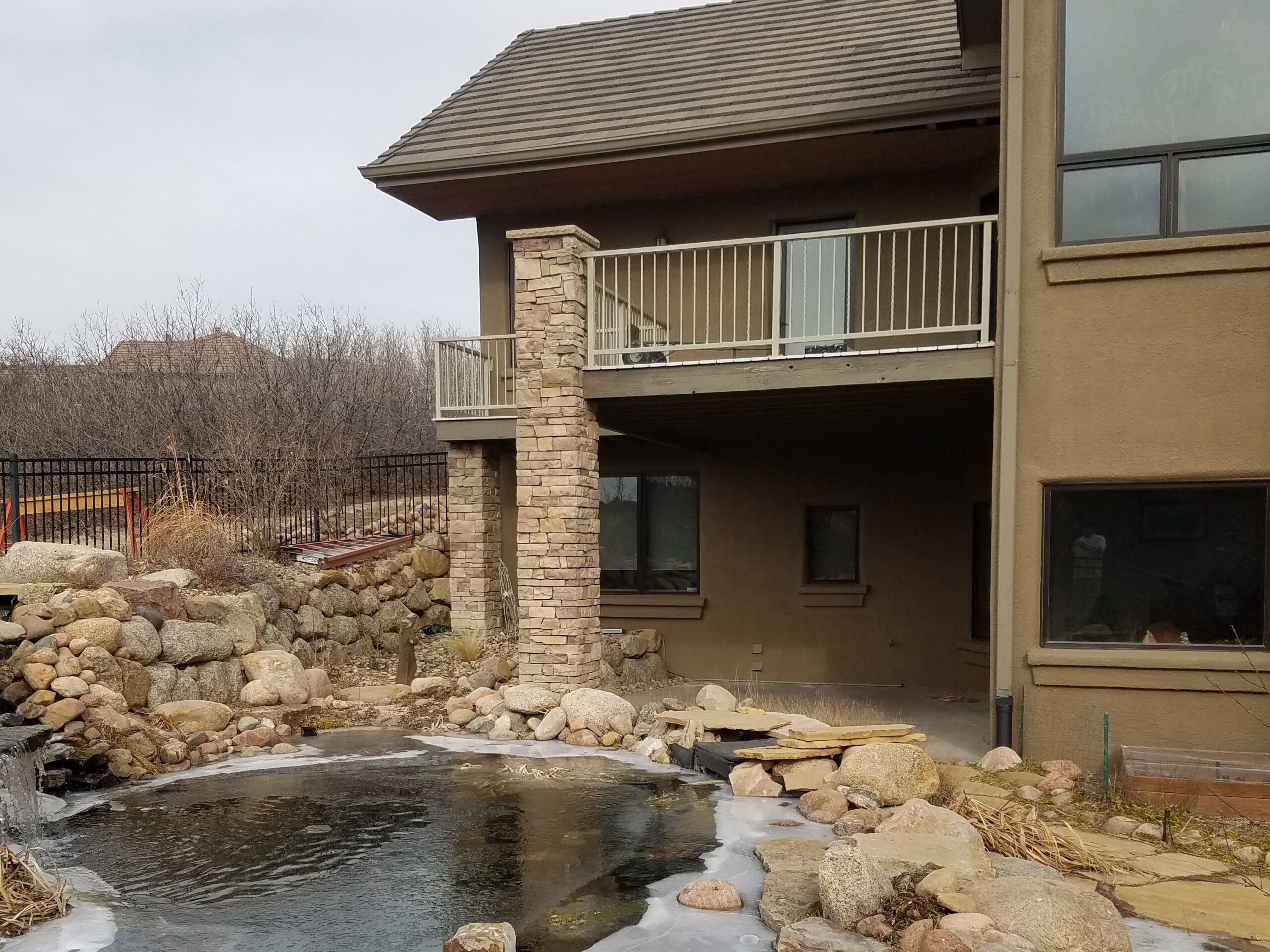 Composite deck with custom steel deck railing overlooking a private pond in University Park area of Colorado Springs