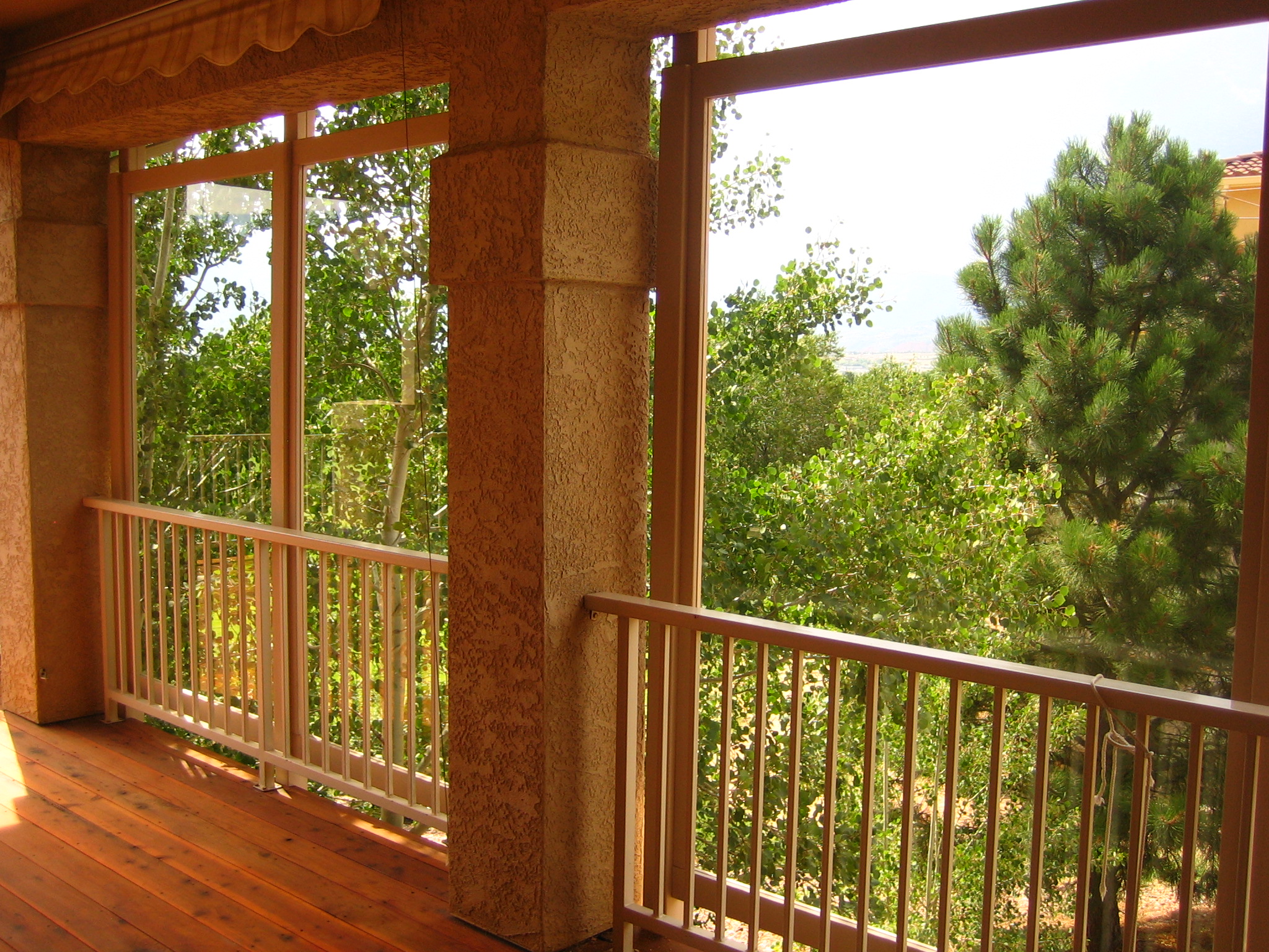 Northeast Colorado Springs redwood deck featuring glass windbreaks and steel deck railing