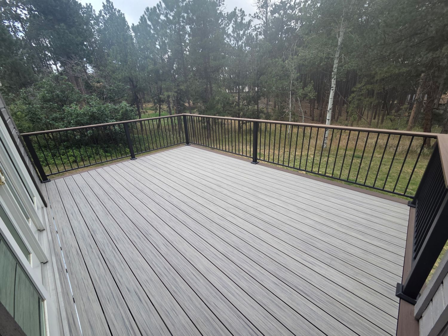 Composite deck in Monument Colorado that features steel deck framing, Deckorators Tundra decking with a 3-sided picture frame border in Khaya
