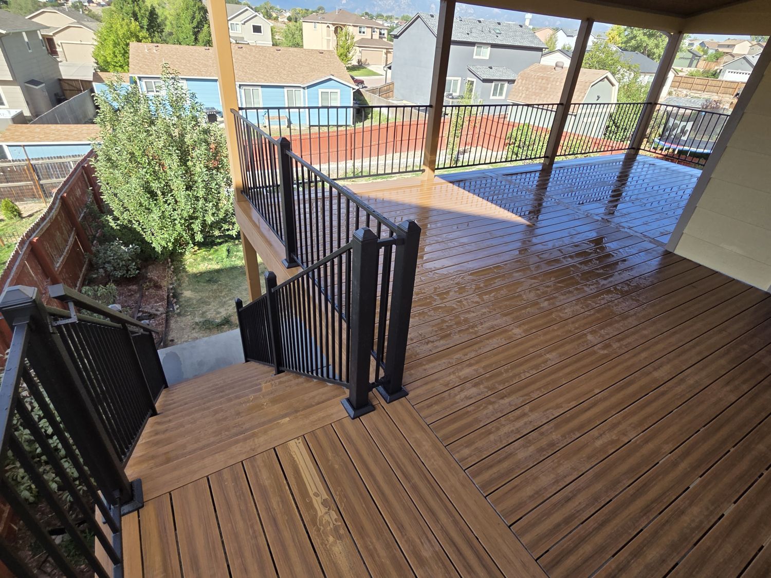 Custom composite deck in Colorado Springs with steel deck railing and shed roof style deck cover
